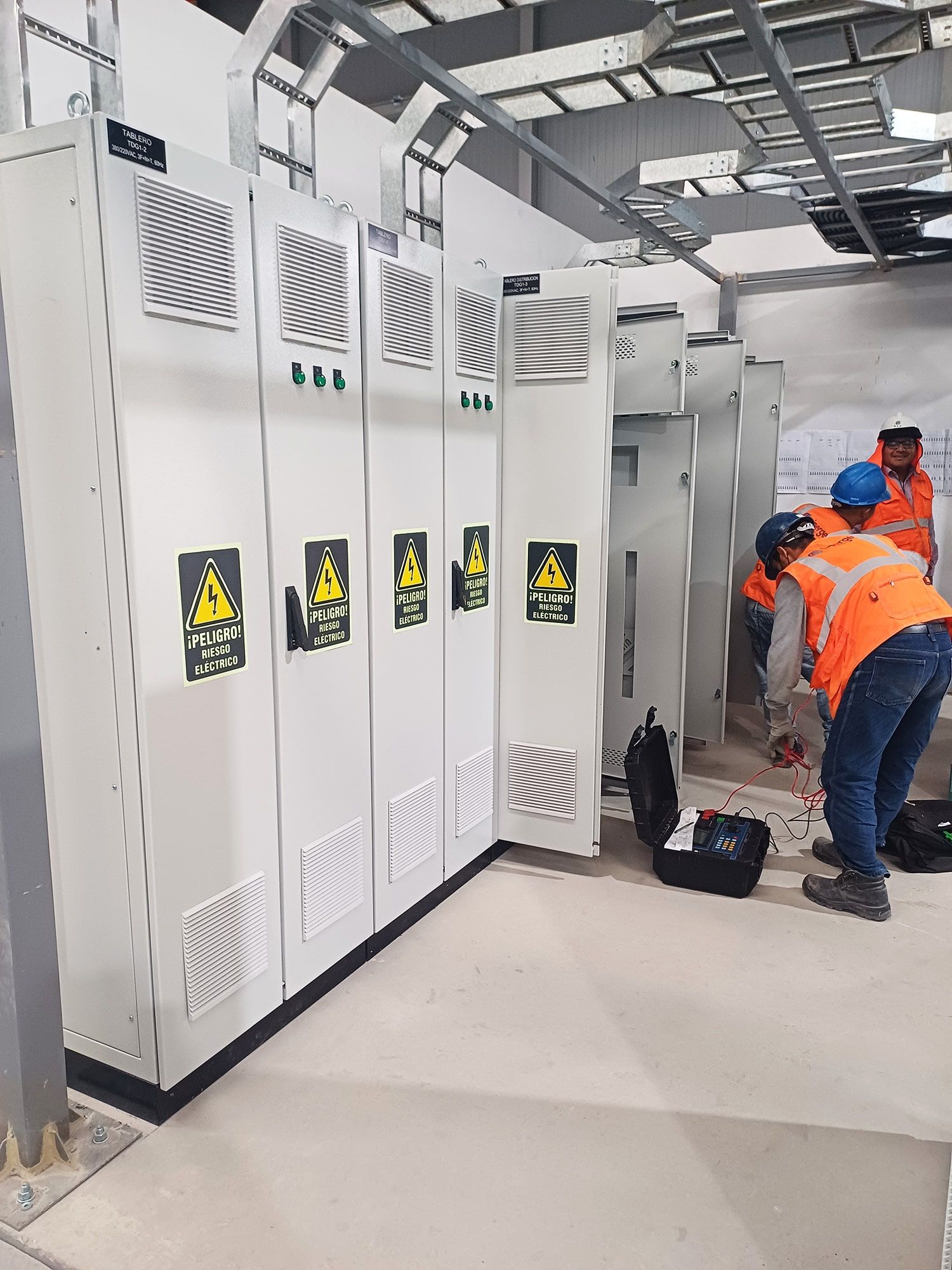 Un grupo de hombres está trabajando con equipos eléctricos en una habitación.