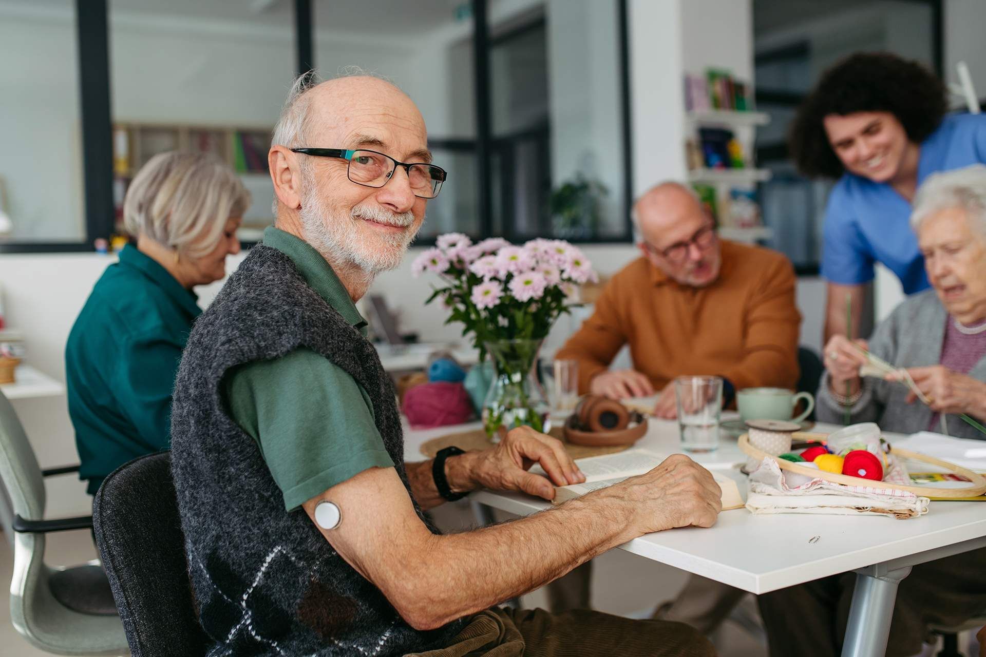 People gathered around a table sharing dessert and coffee in a bright dining room