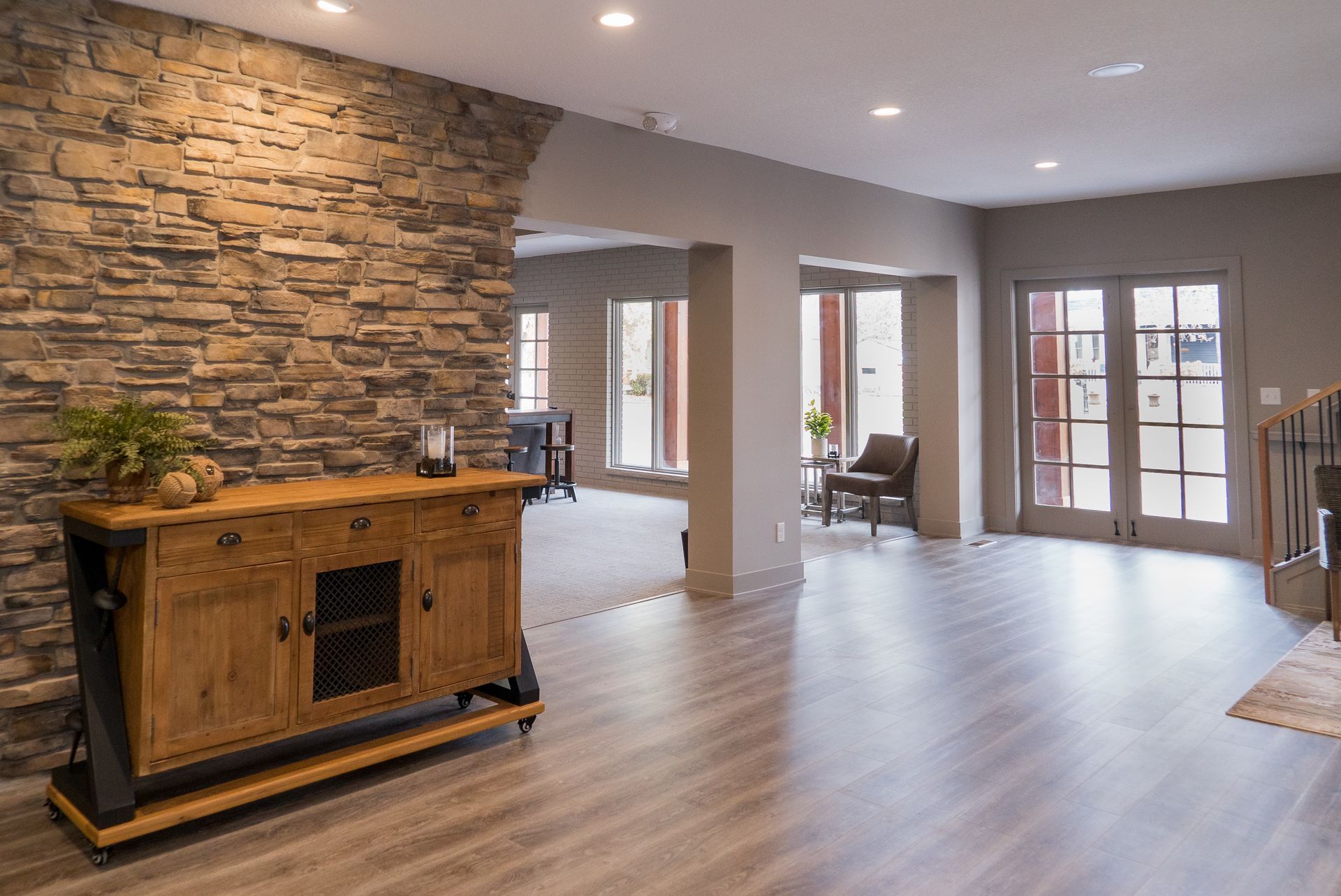 A living room with a wooden dresser and a stone wall.