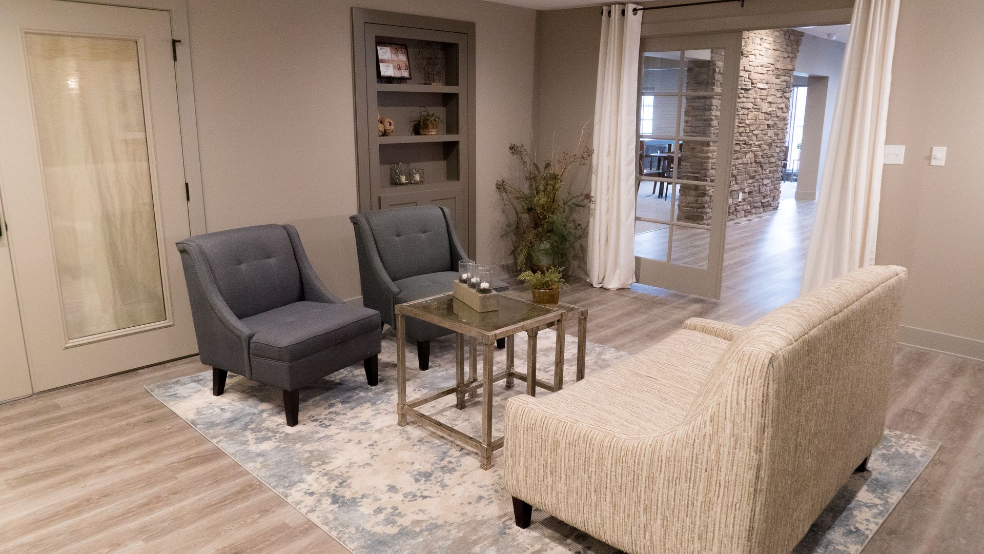 A living room with a couch , chairs , and a table.