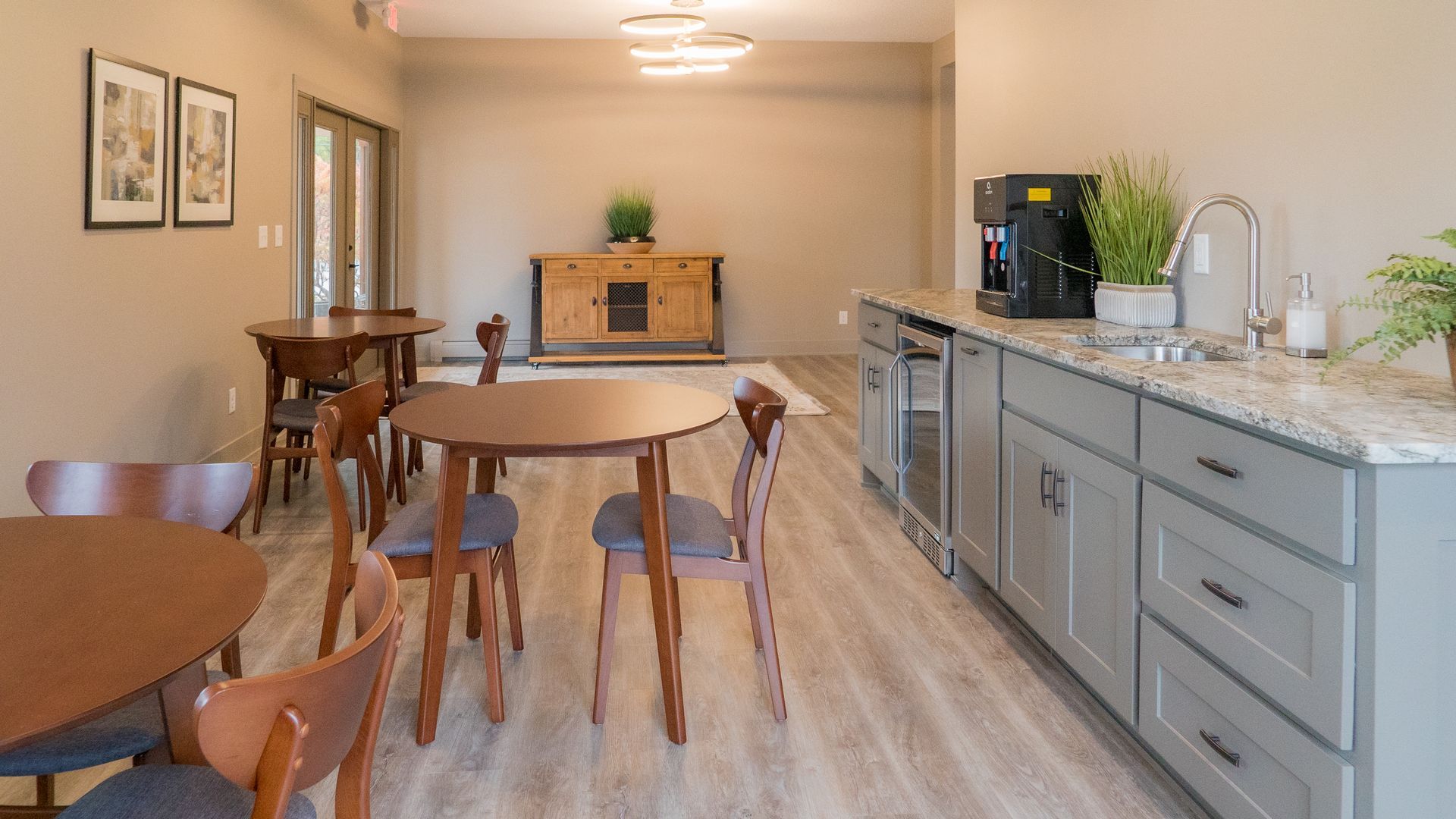 A large room with tables and chairs and a kitchen.