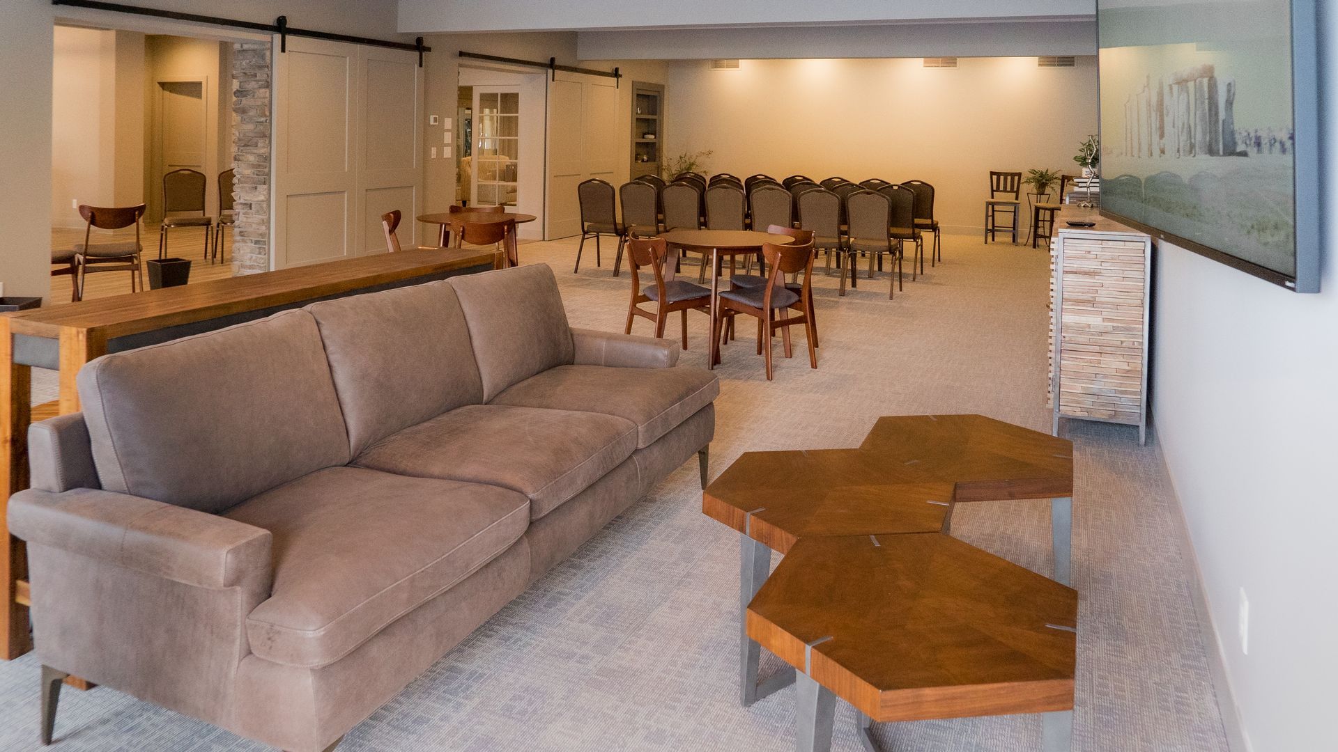 A living room with a couch , tables , chairs and a television.
