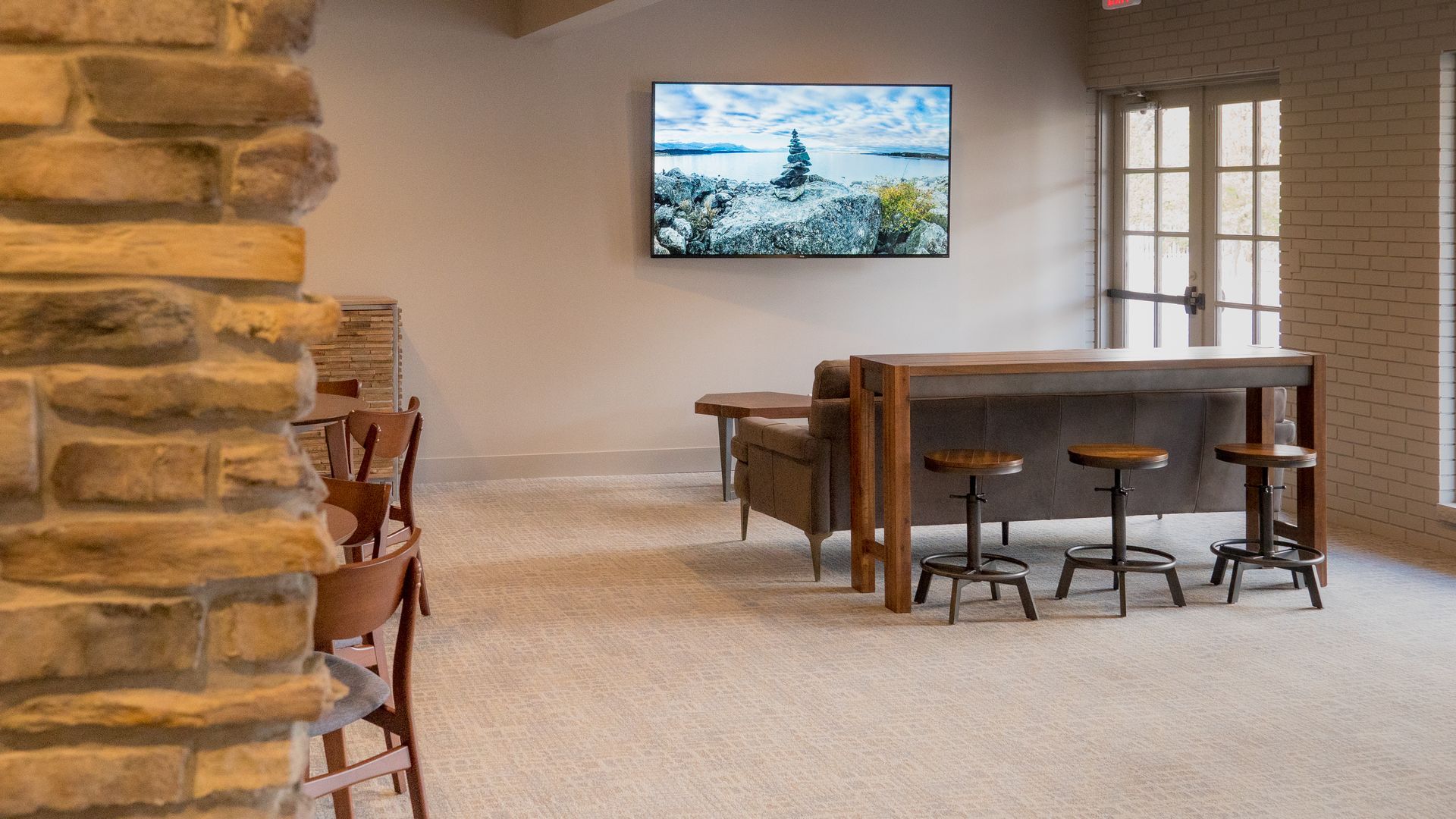 A living room with a couch and a television on the wall.