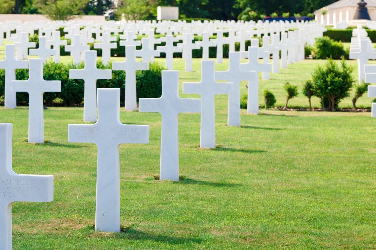 Rows of white crosses marking graves at an American army cemetery honoring fallen veterans