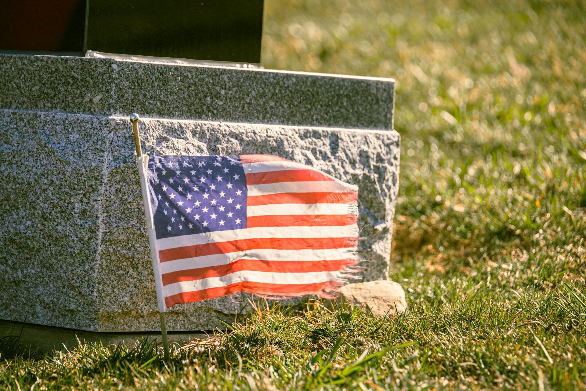 American flag placed on a grave honoring fallen service-members and reflecting patriotism & sacrife