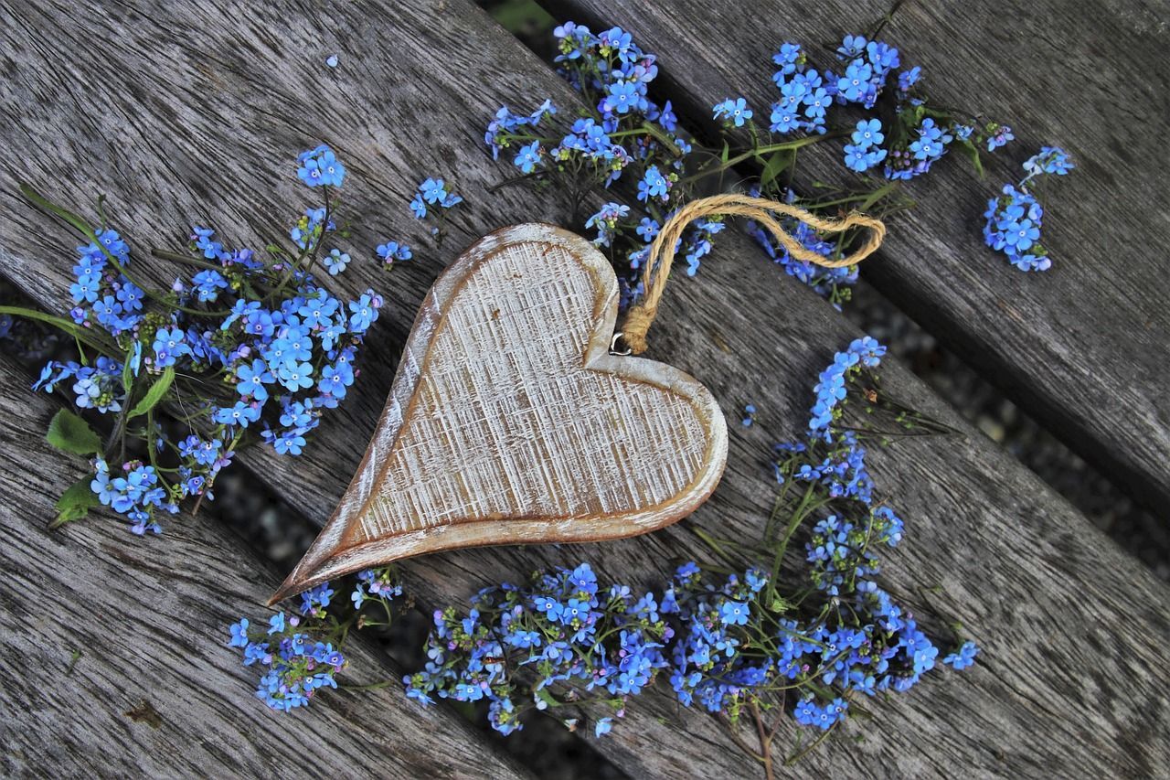 Wooden heart with “Don’t forget about me” message placed on a grave in a cemetery