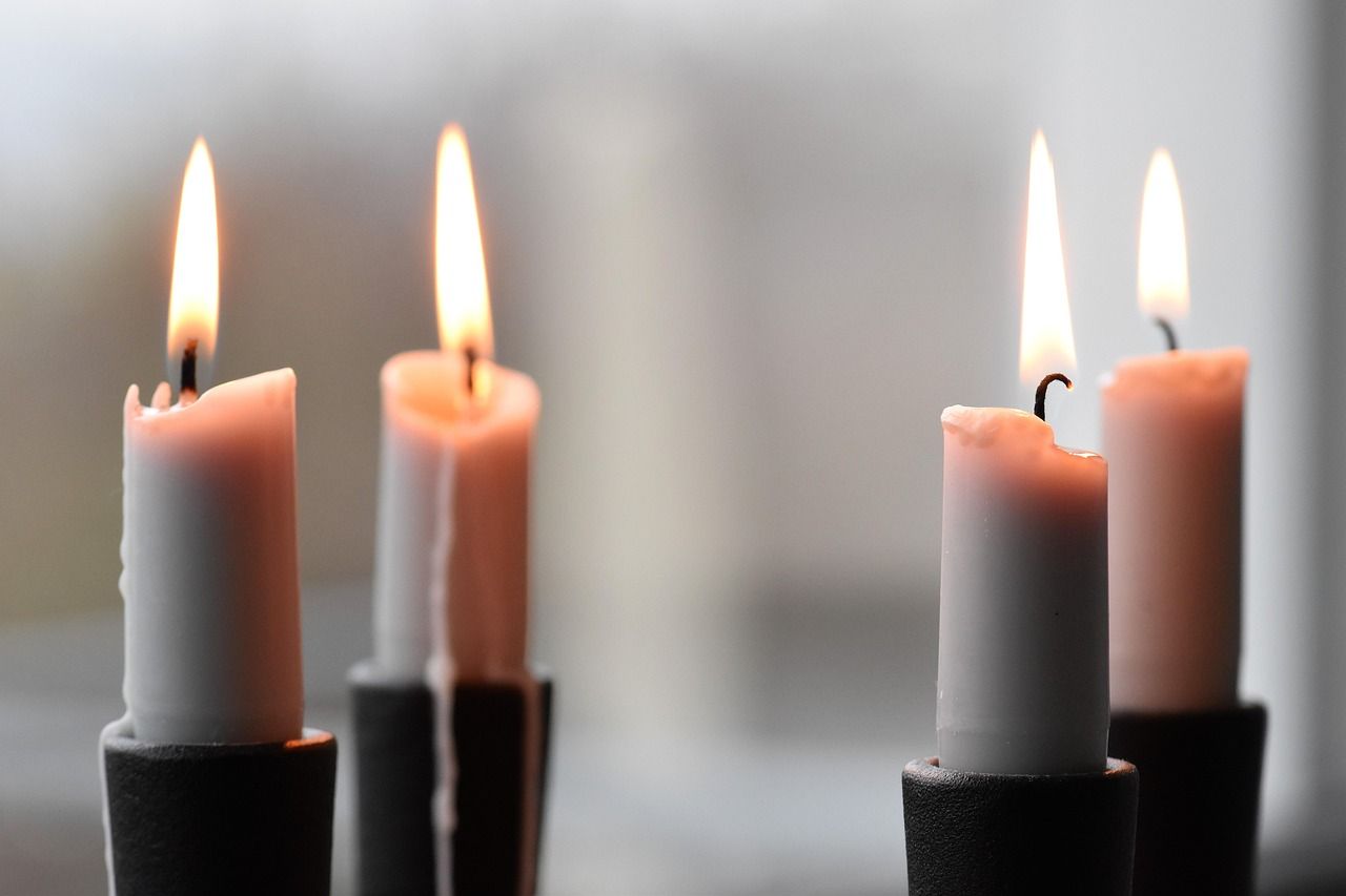 Close-up of a lit candle flame casting warm light