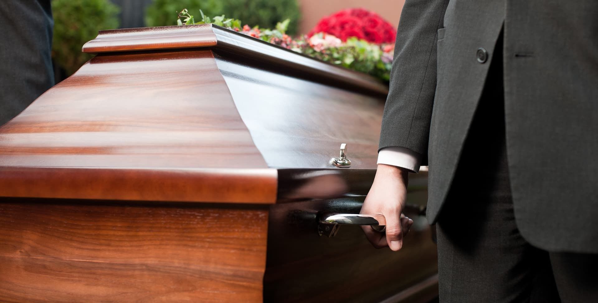 a wooden coffin with flowers on top of it