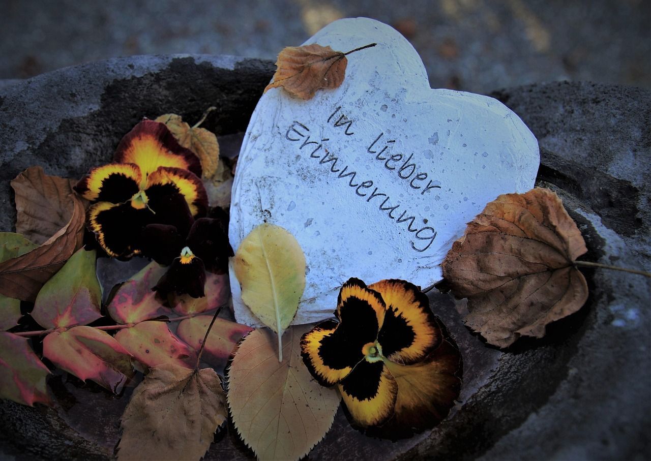 Stone heart with “Memory” and “Goodbye” engraved, placed at a cemetery memorial