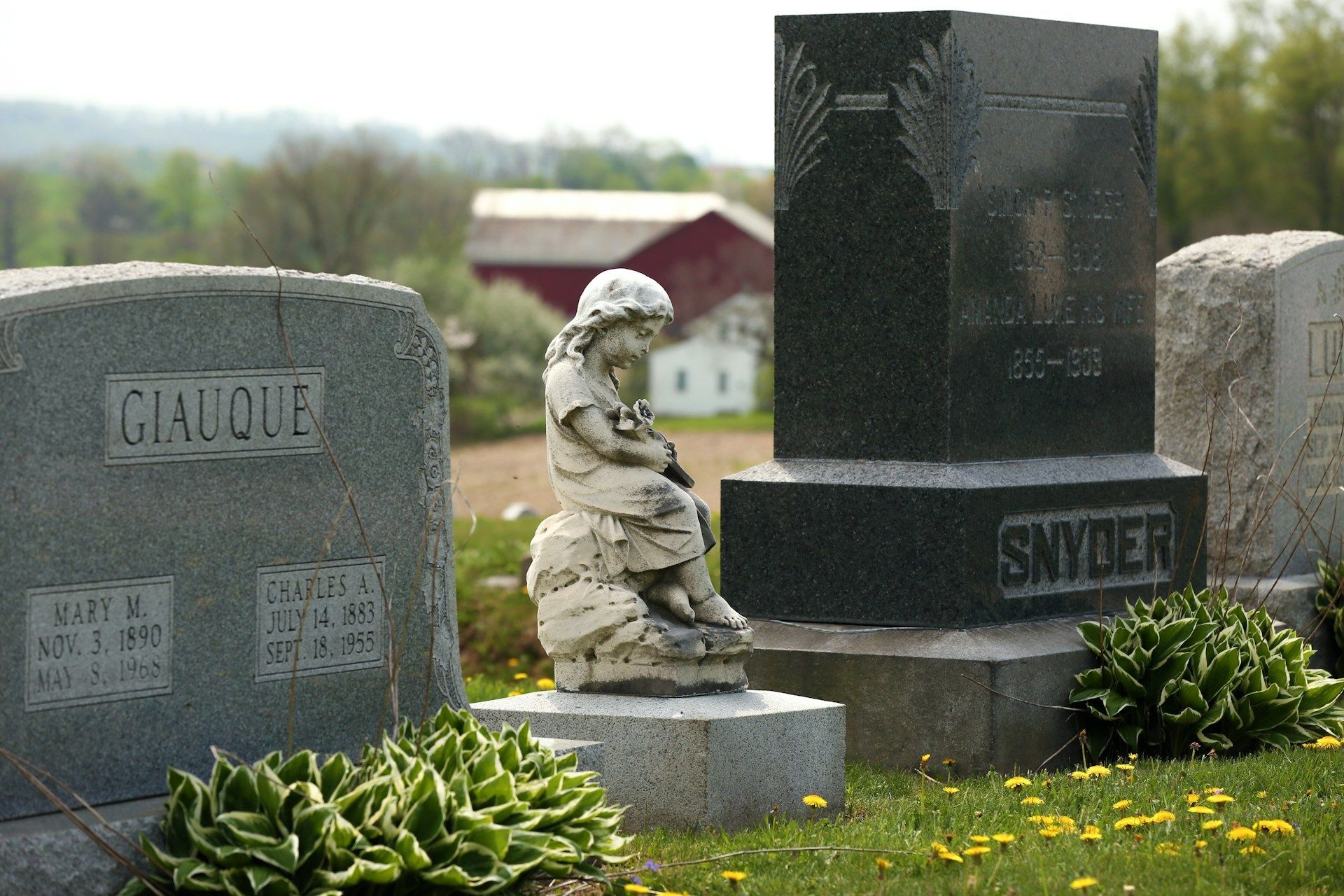 Sculpted tombstone with a seated child figure in daytime light reflecting memory and solemn honor.
