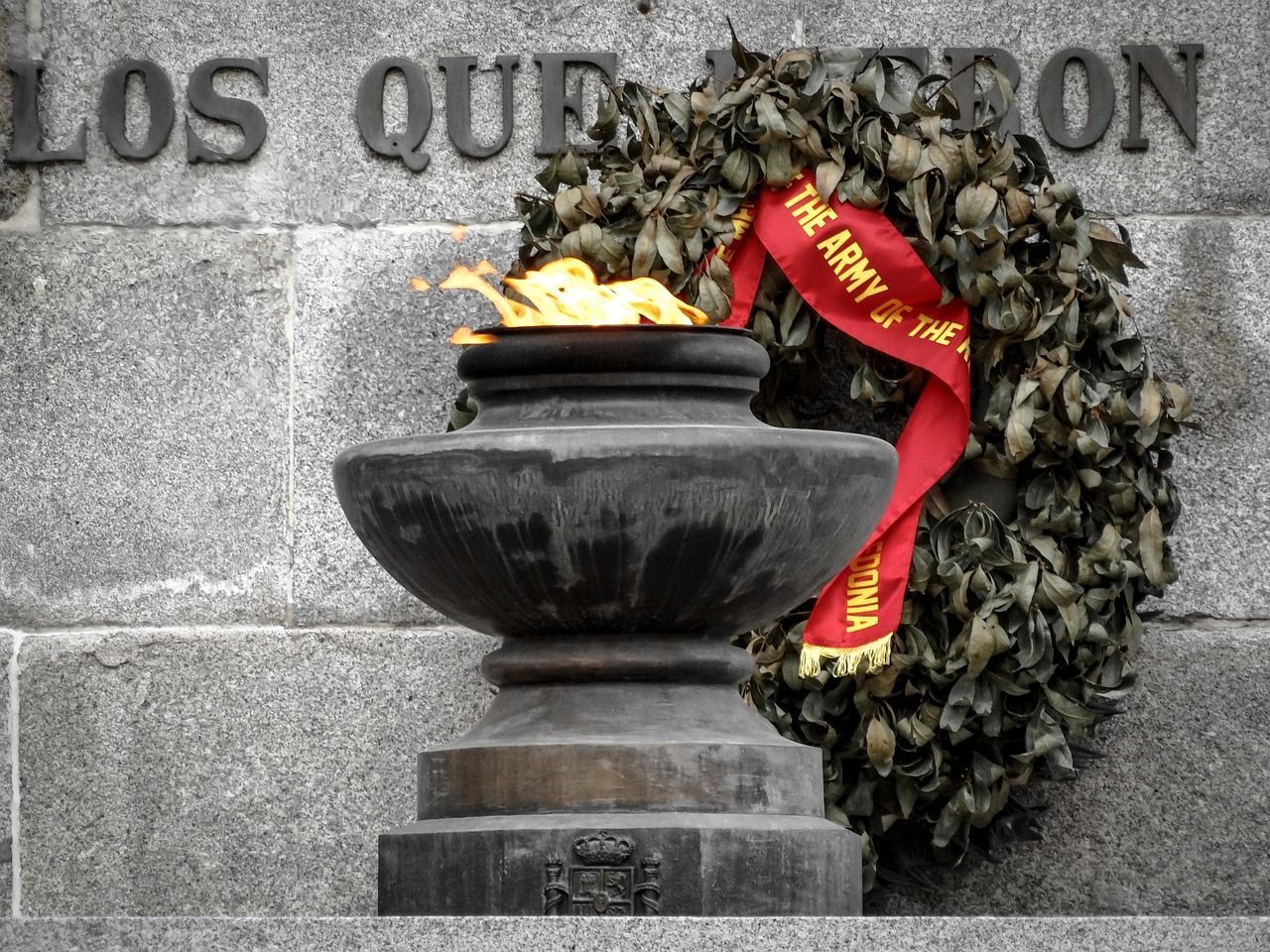 War memorial statue honoring soldiers with wreaths and flags