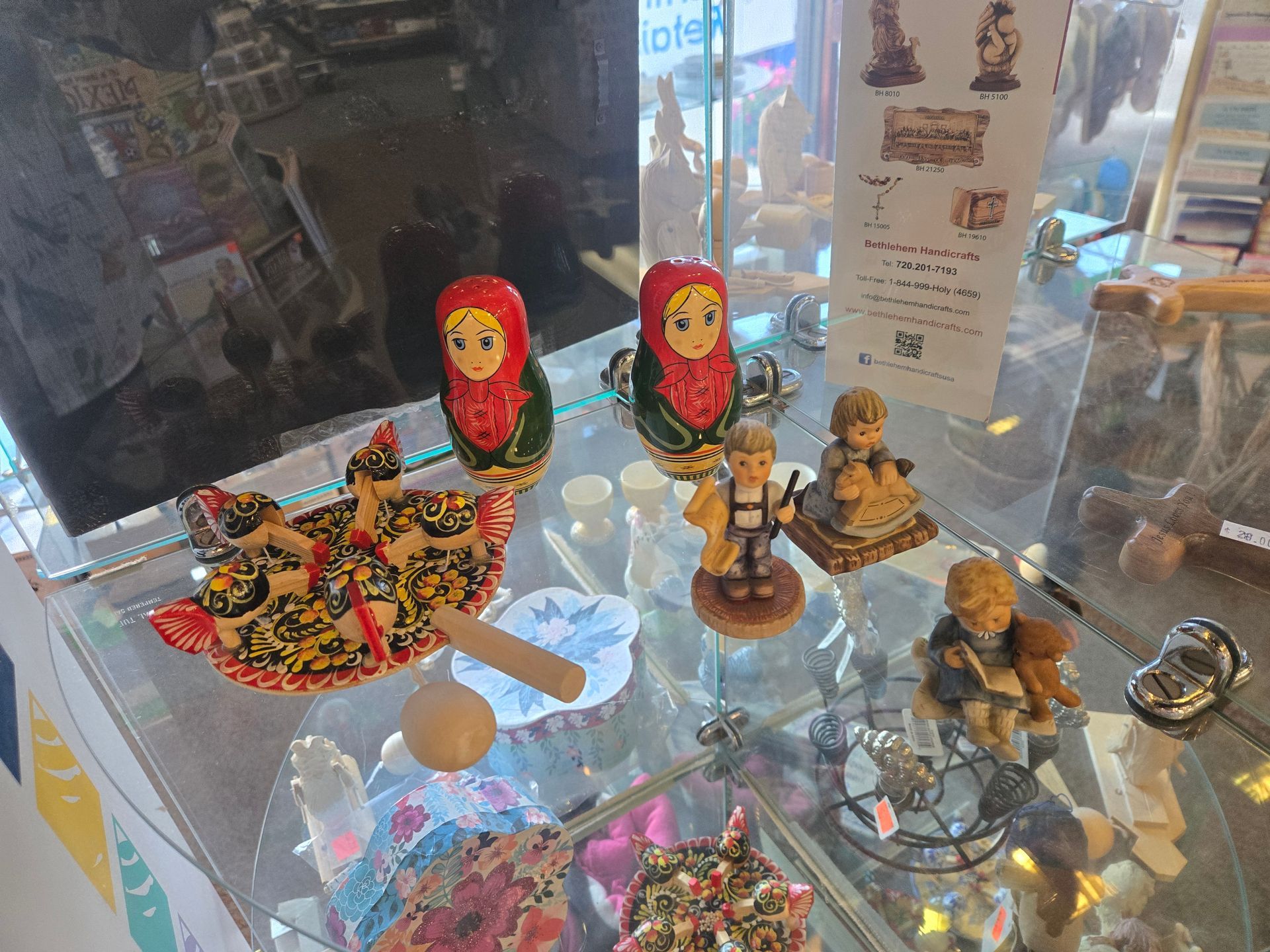Display case with Russian nesting dolls, figurines, and various trinkets.