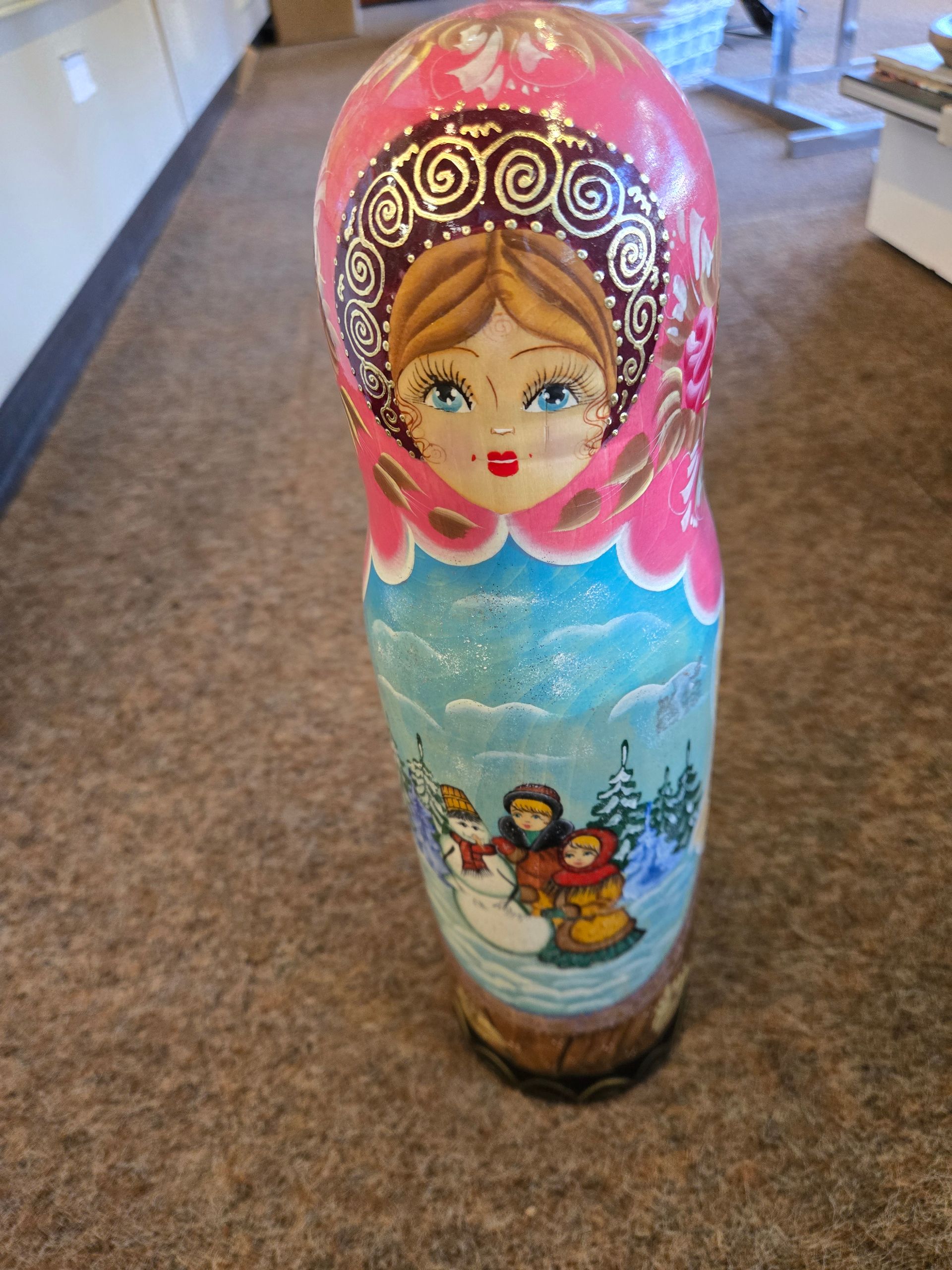 Russian nesting doll, pink top, winter scene with snowman, painted wooden toy.