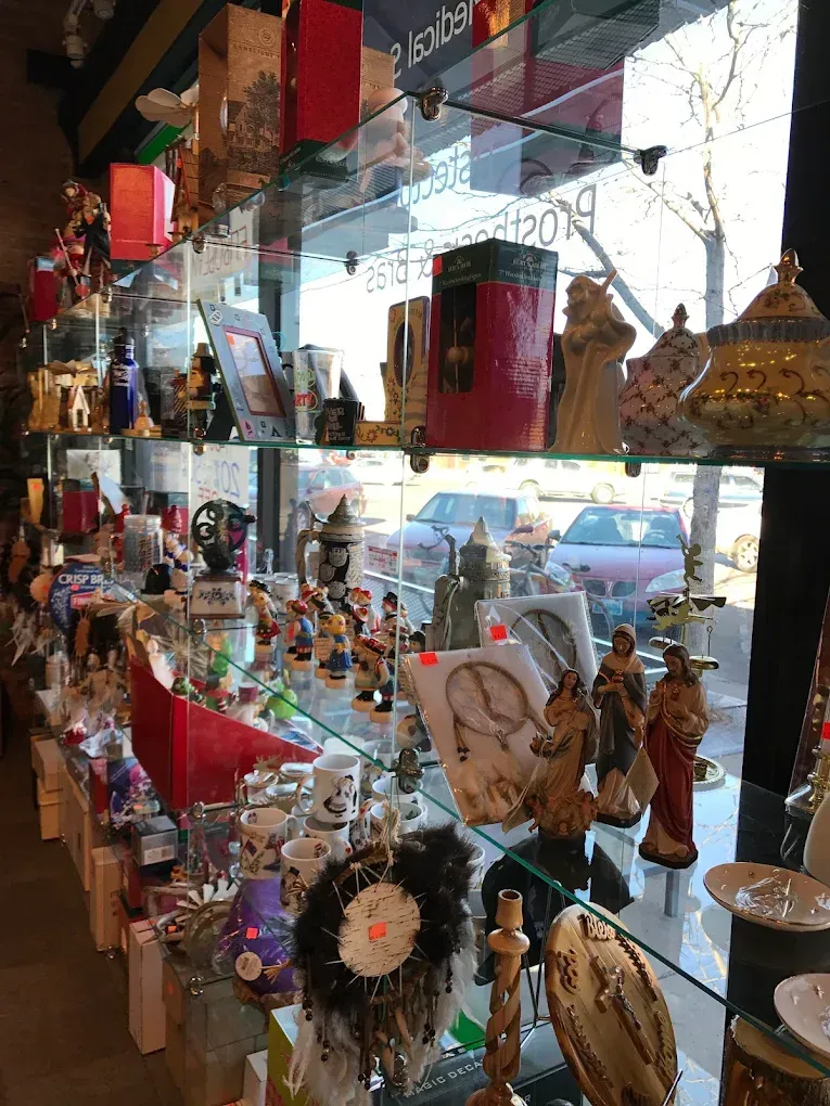 Glass shelves displaying various gift items inside a store, seen through a window.