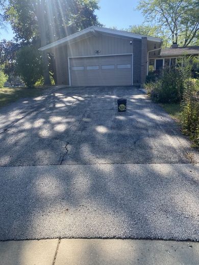 A house with a garage and a driveway in front of it.