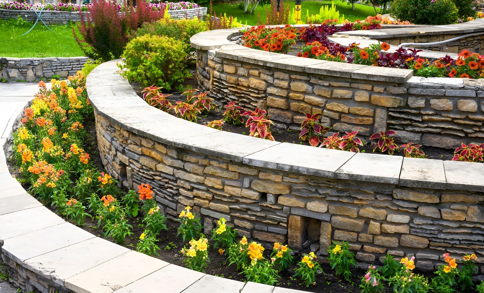 Stone Tiered Garden Beds Filled with Colourful Flowers — Bigfoot Earthmoving In Byron Bay, NSW