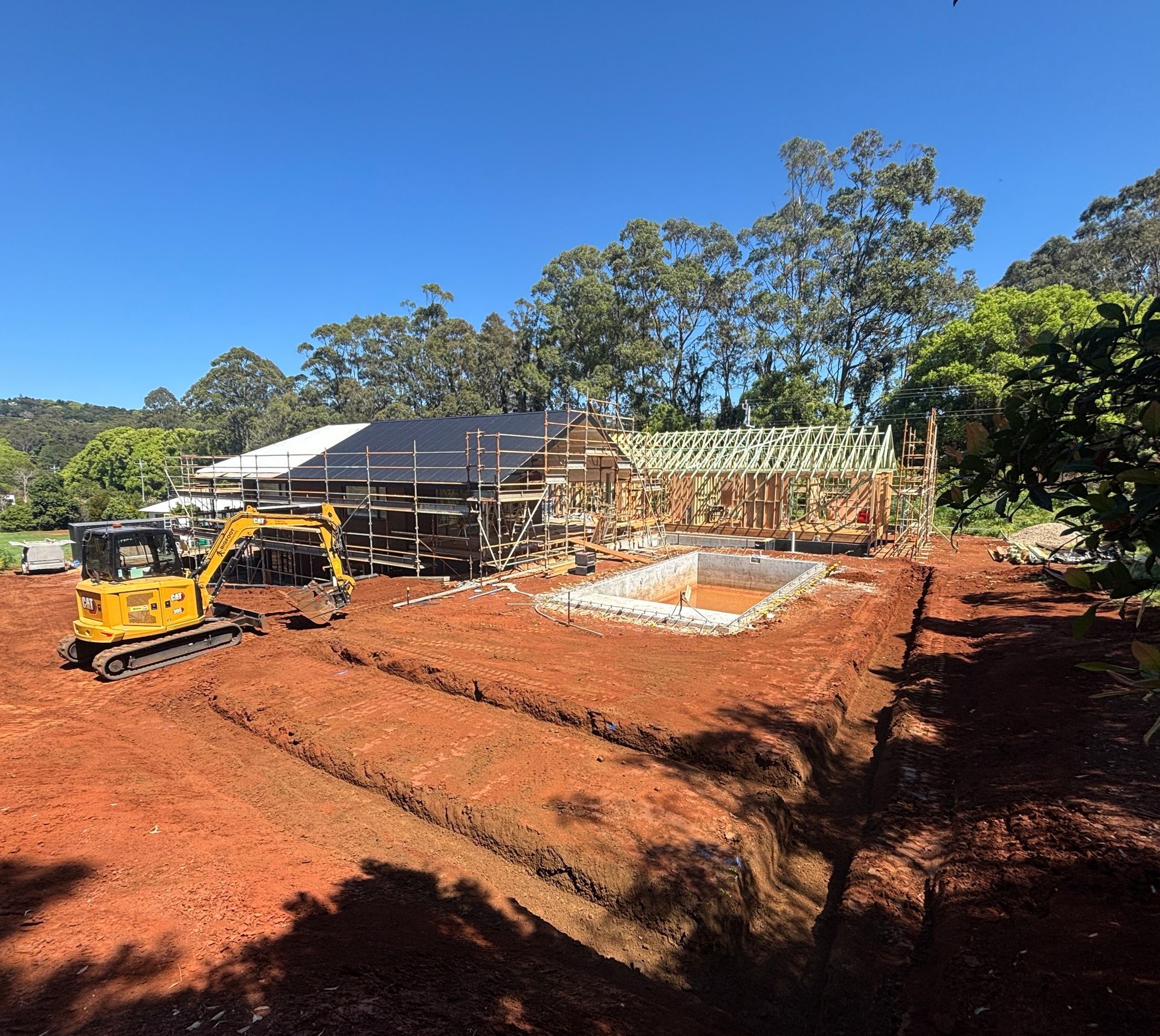 Yellow Loader Dumping Dirt on A Construction Site Under a Blue Sky — Bigfoot Earthmoving In Byron Bay, NSW