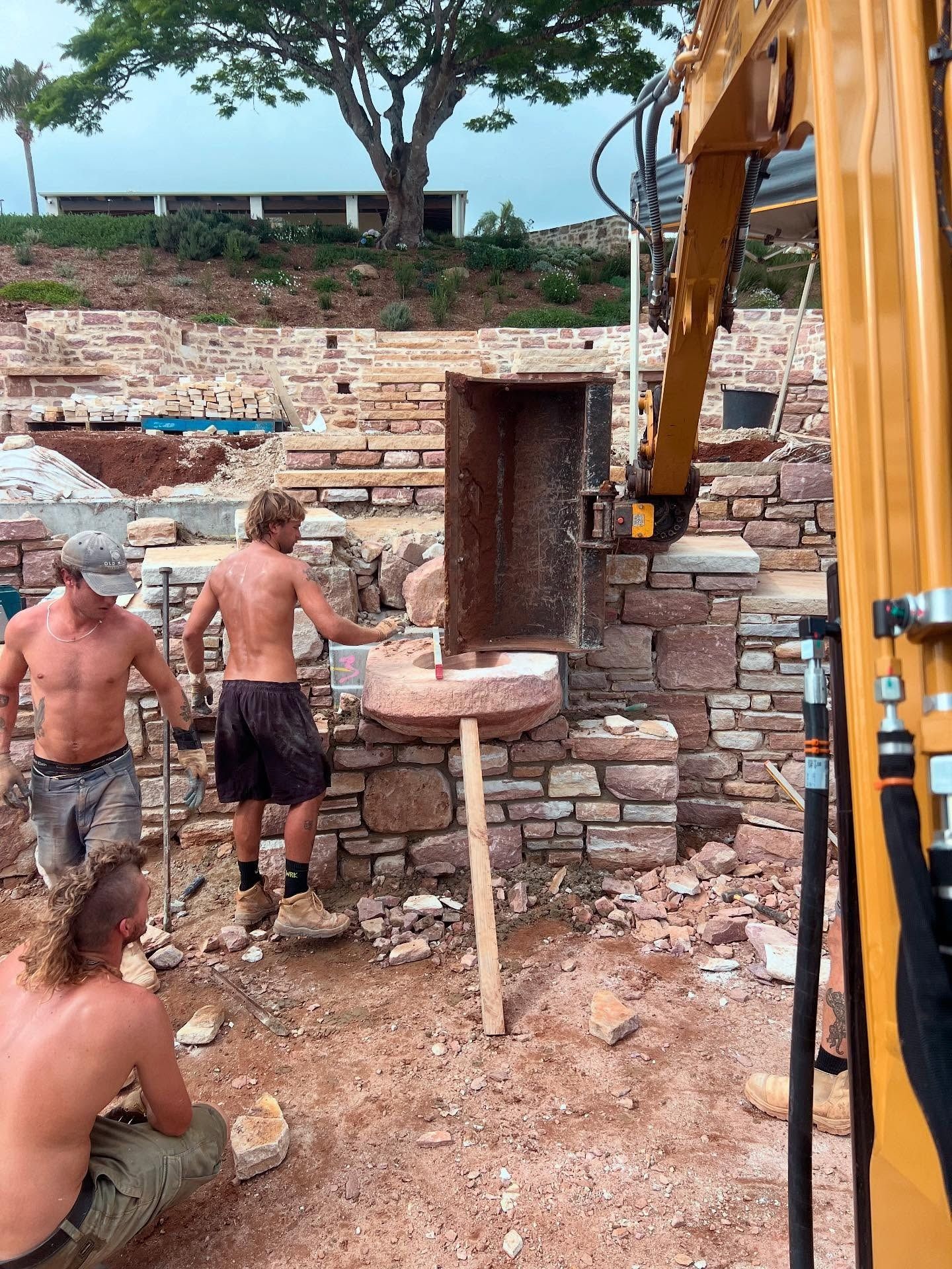 Construction Workers Building with Stone Blocks — Bigfoot Earthmoving In Byron Bay, NSW