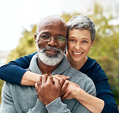A woman is hugging a man with a beard.