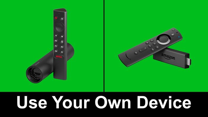 A pair of remote controls sitting next to each other on a green screen.