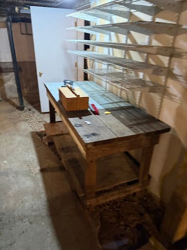 A wooden table with a box on top of it in a room with shelves.