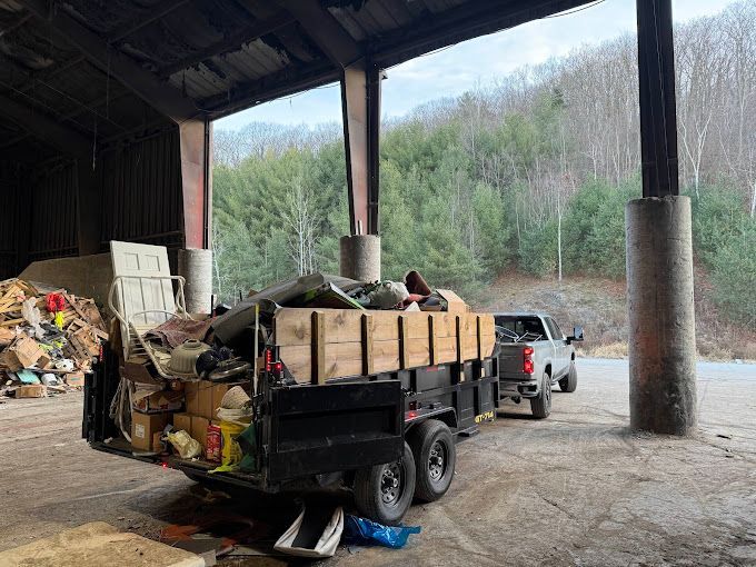 A black trailer full of household debris. 