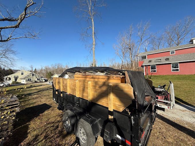 A dump truck is parked in front of a red house.