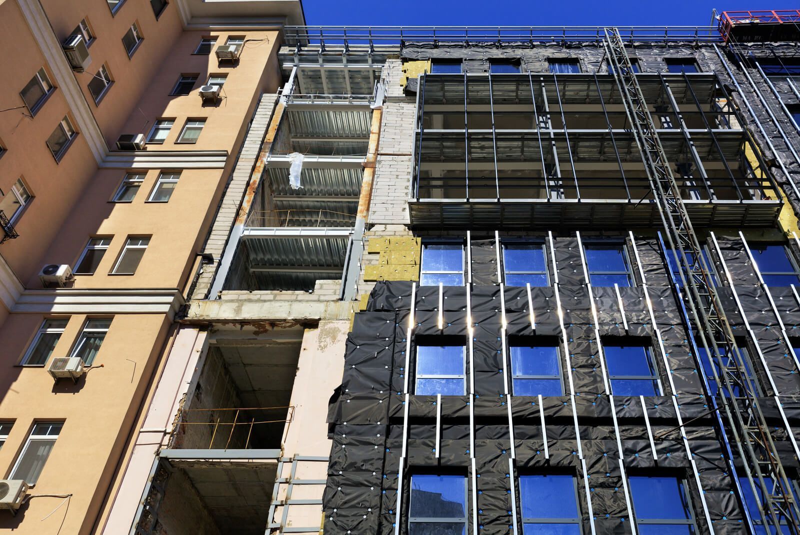 A large commercial building with insulation being installed into it