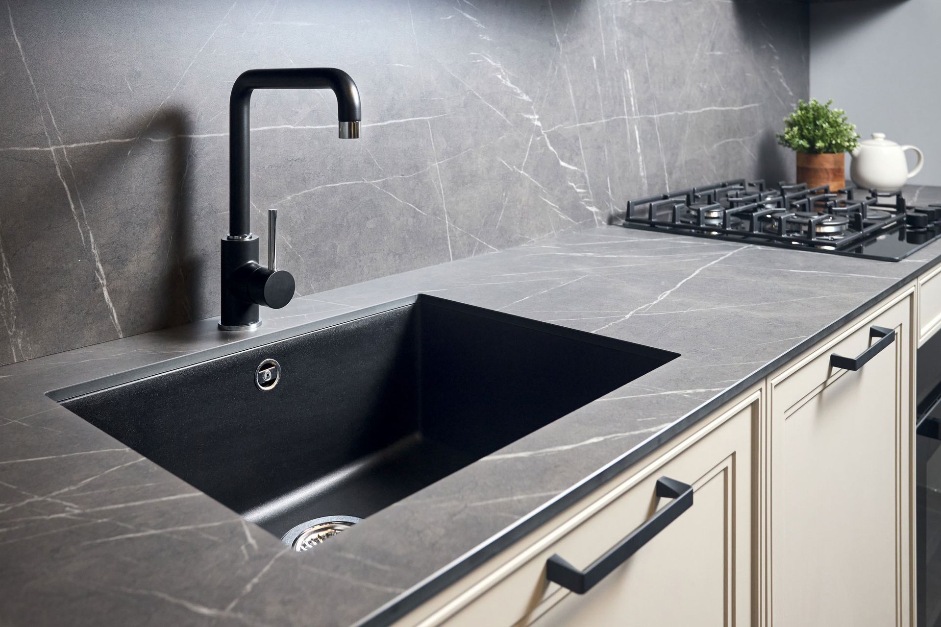 A kitchen with a black sink and a black faucet.