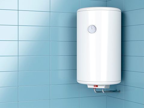 A white water heater is hanging on a blue tiled wall in a bathroom.