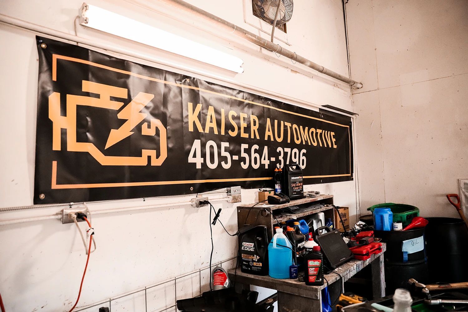 Banner for Kaiser Automotive with contact number in garage setting | Kaiser Automotive
