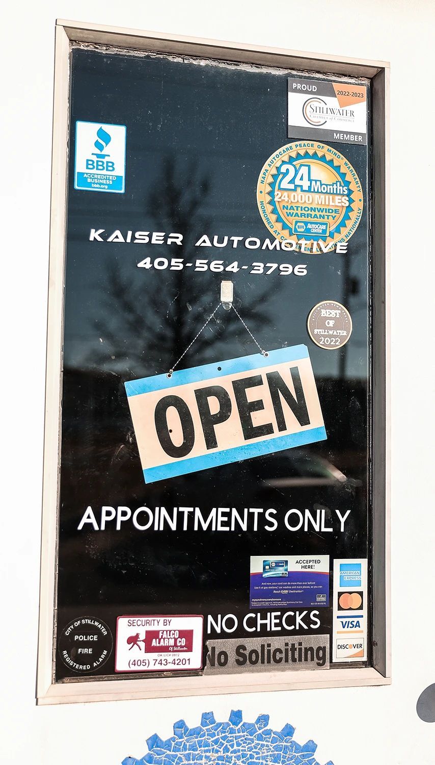 Kaiser Automotive window: Open sign, phone number, and logos for automotive services  | Kaiser Automotive