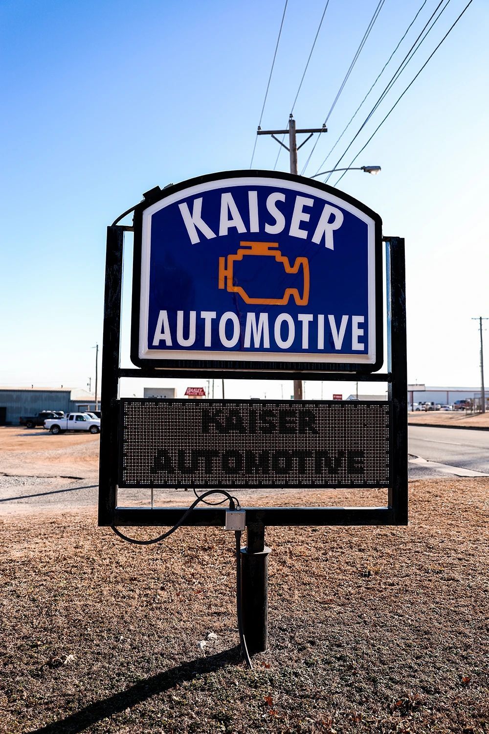 Sign for Kaiser Automotive. Blue sign with white lettering. Orange engine light symbol | Kaiser Automotive