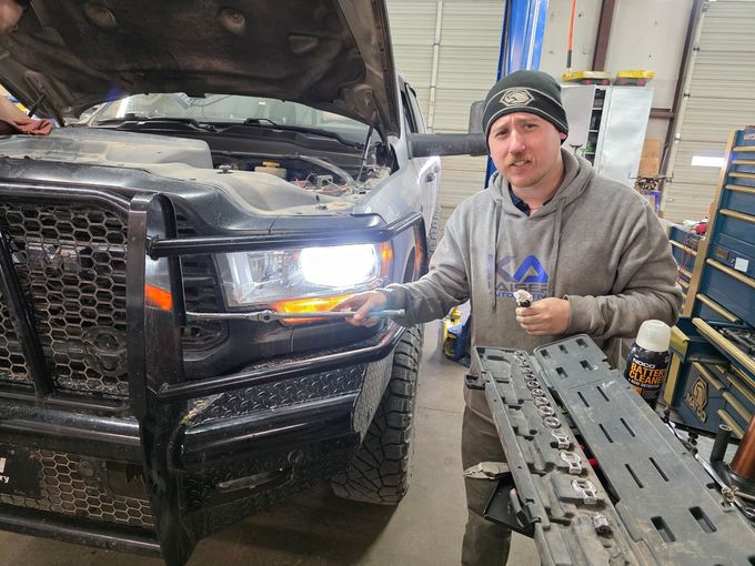 Our Technician is Checking a Truck's Headlight in Our Garage in Stillwater, OK | Kaiser Automotive