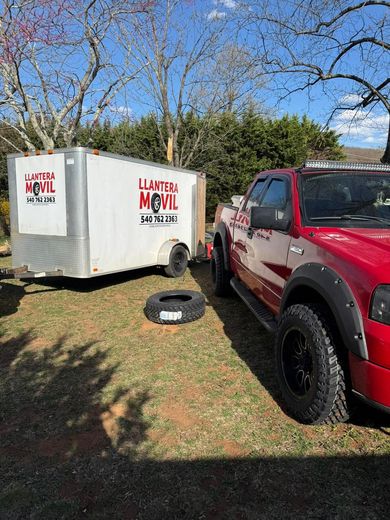 A red truck is parked next to a white trailer.