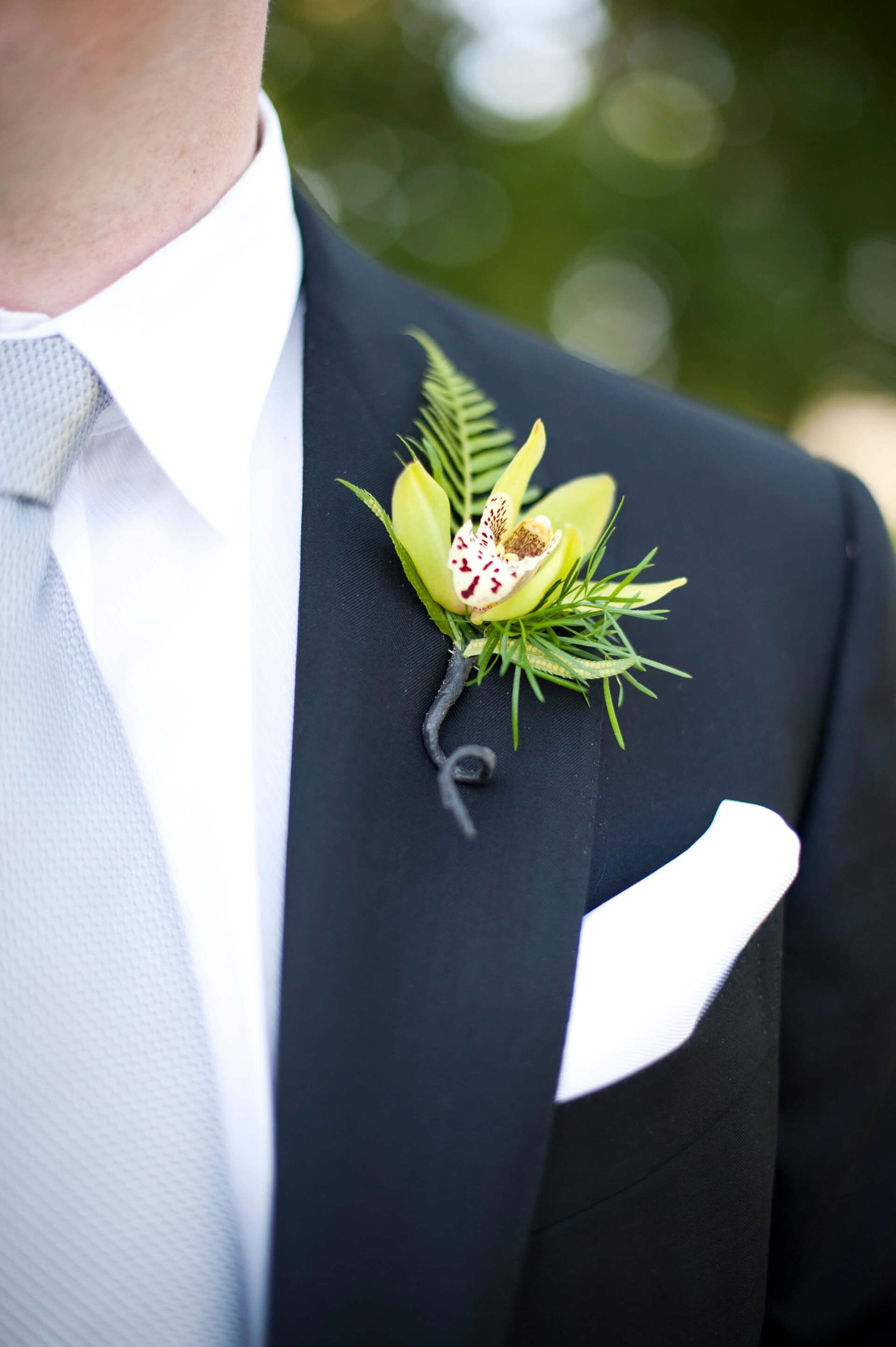A man in a suit has a flower in his pocket - flowers designed by Flowers by Leo