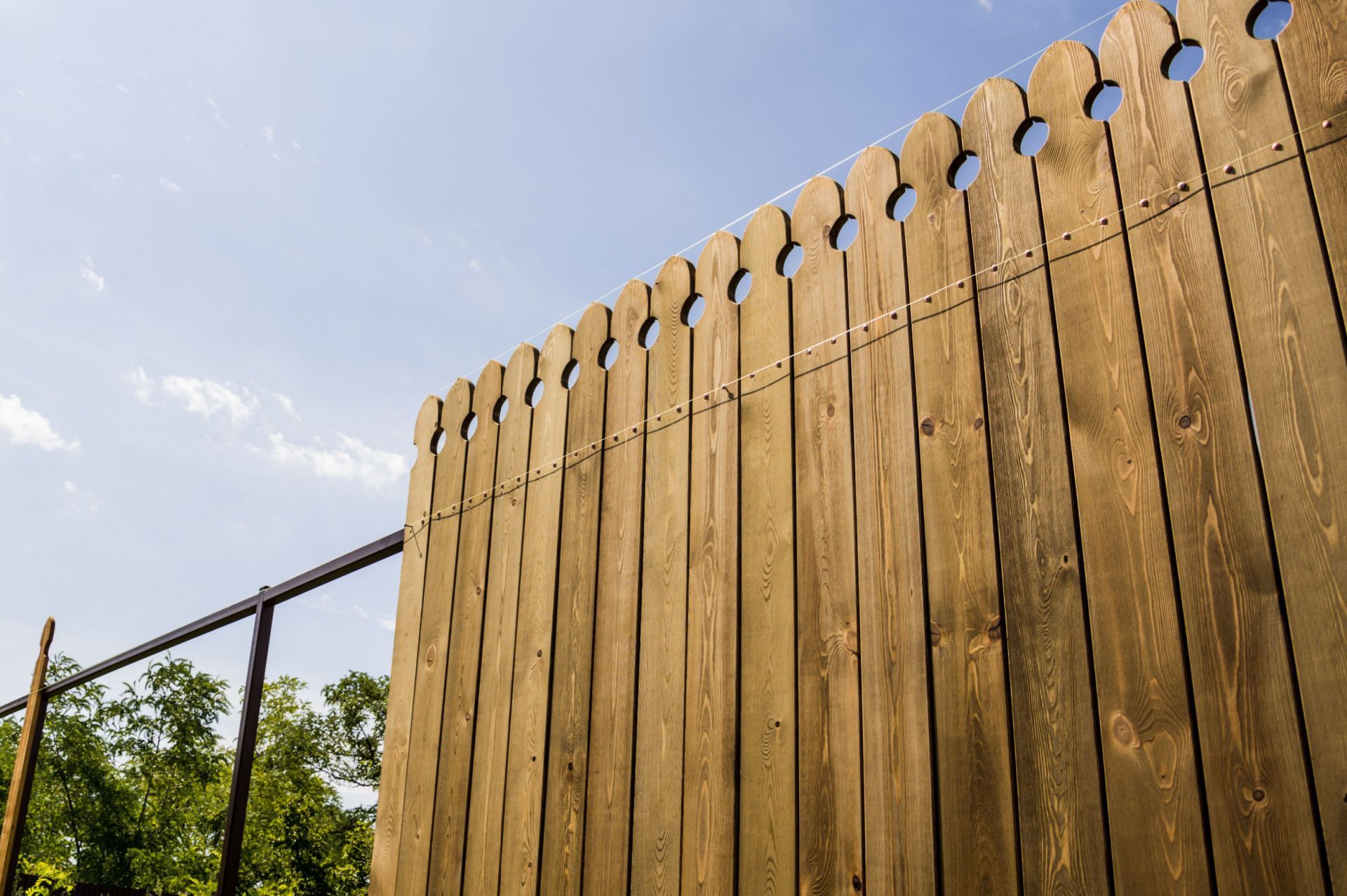 a close up of a wooden fence with a blue sky in the background .