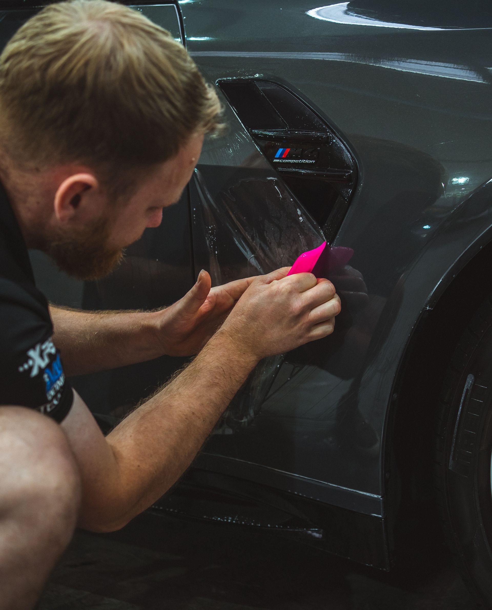 A man is installing PPF on a car