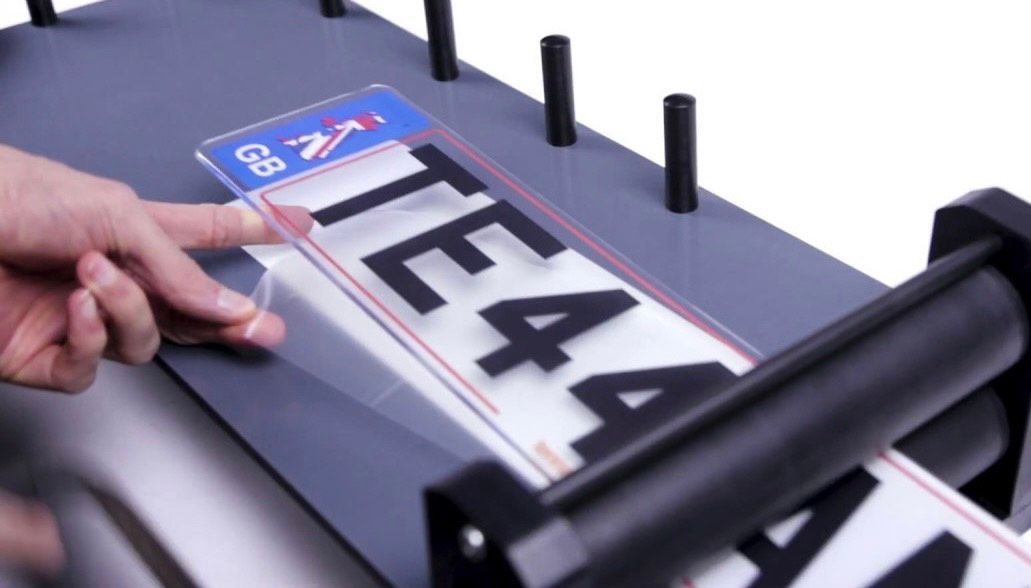 A person is holding a license plate that says team 4