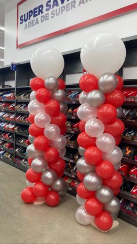 Two columns of red , white and silver balloons in a store
