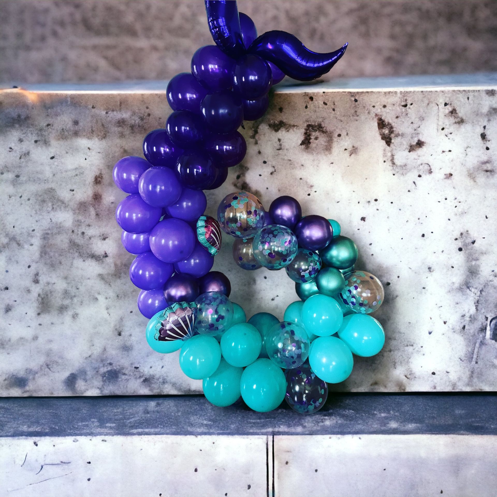 A bunch of purple and blue balloons on a wall