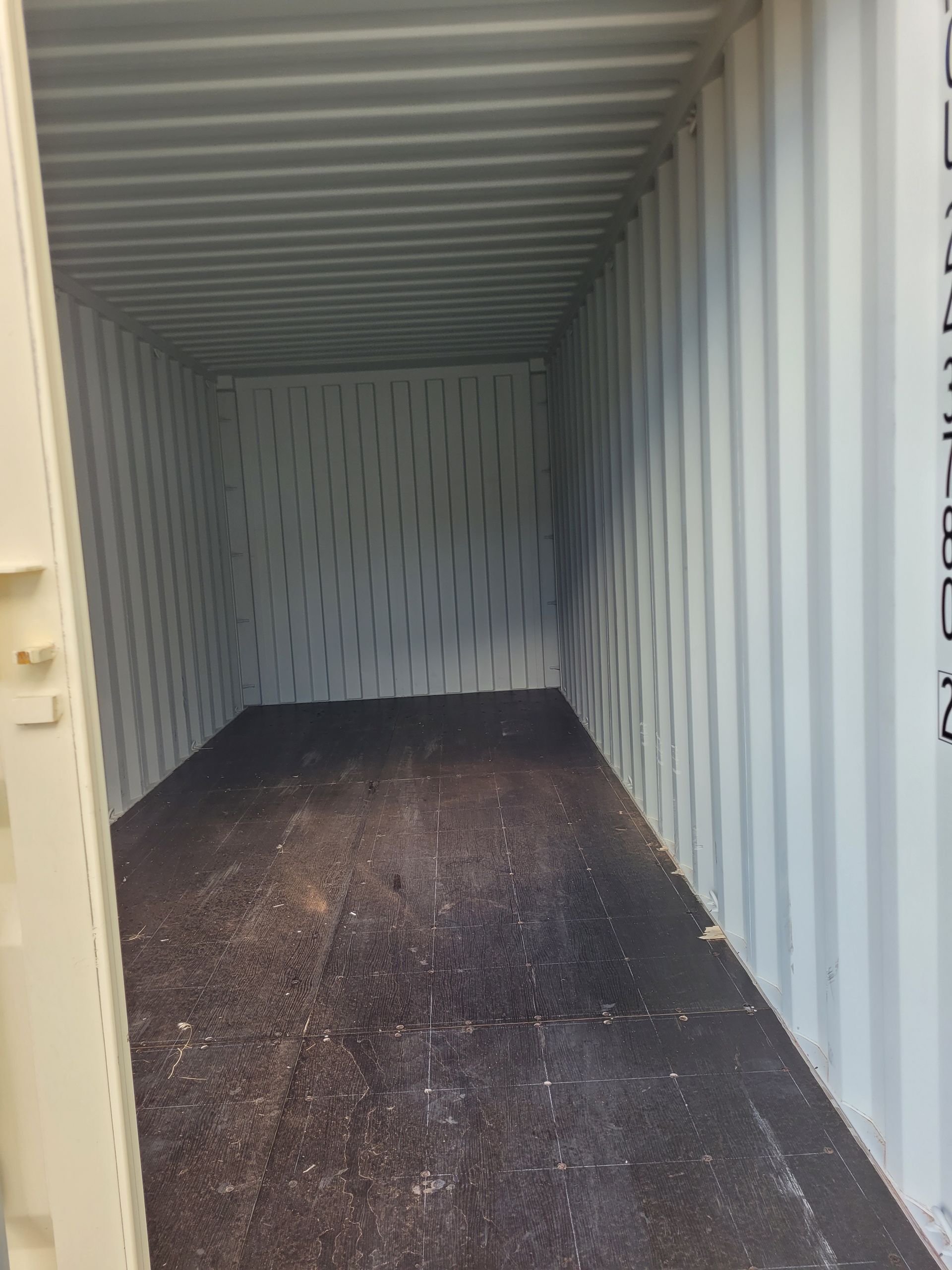 The inside of a shipping container with a lot of dirt on the floor.