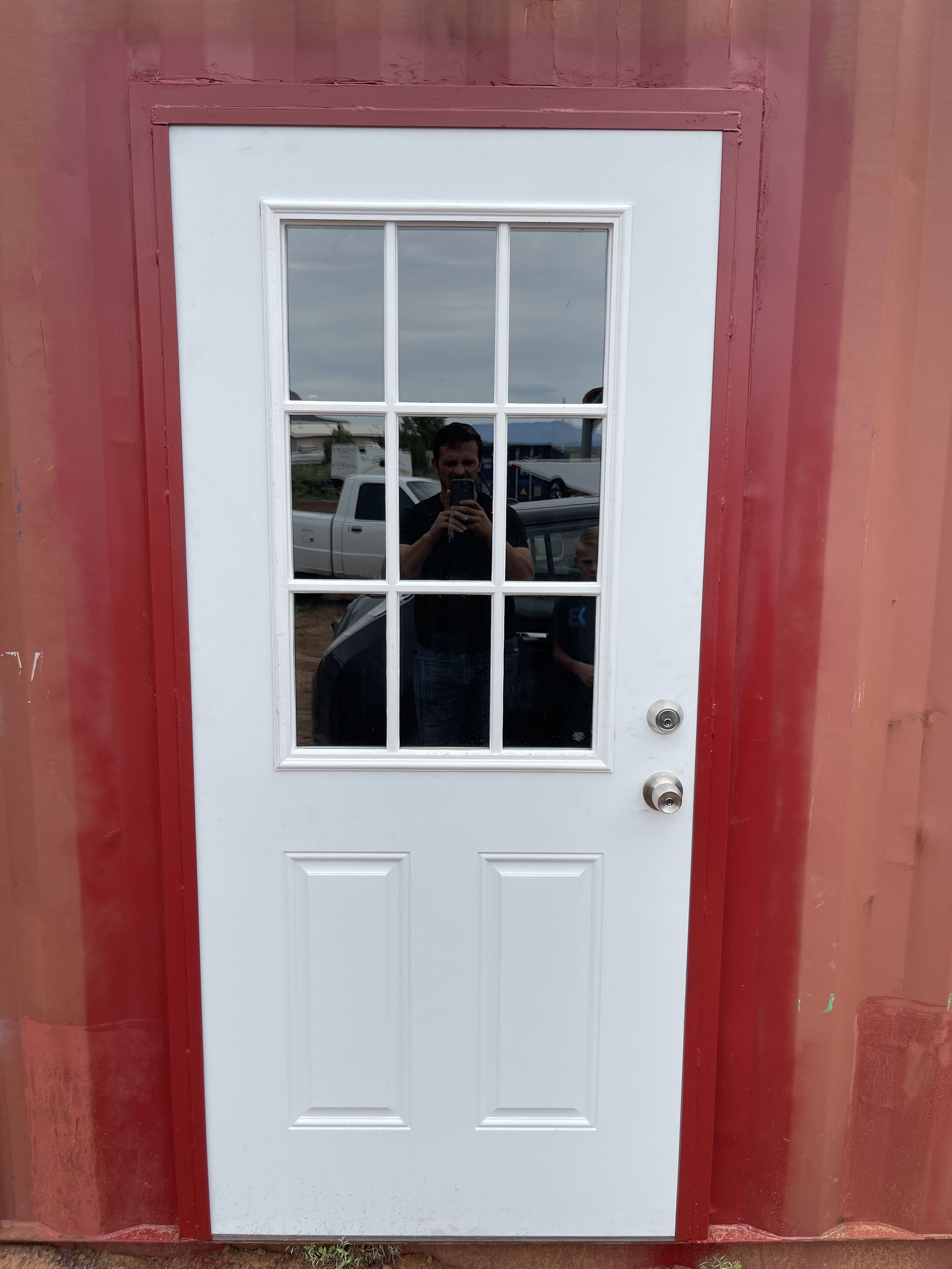 A man is taking a picture of himself in a door.