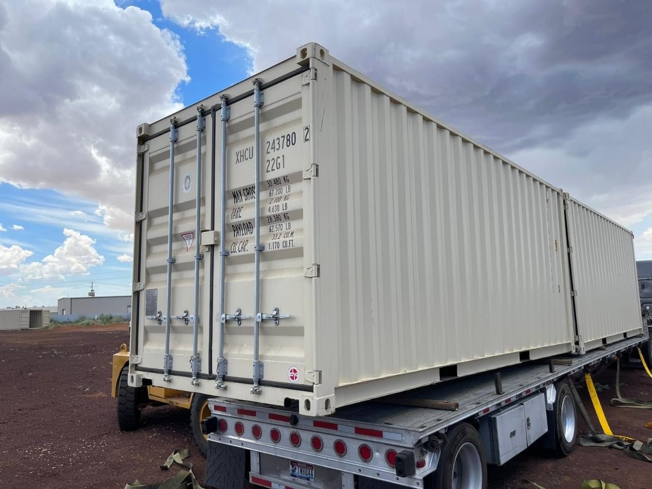 A shipping container is sitting on top of a trailer.