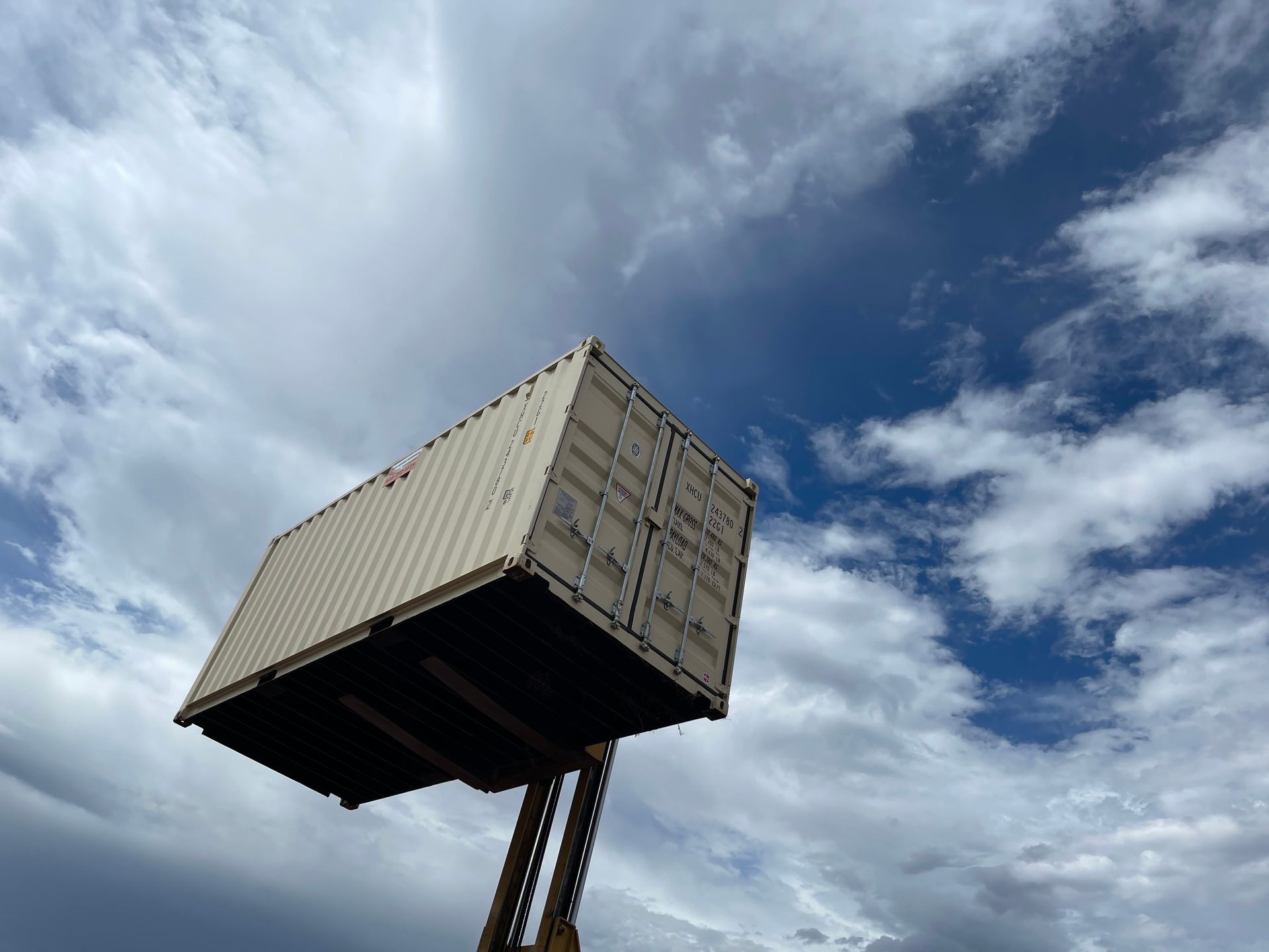 A shipping container is being lifted into the air by a crane.