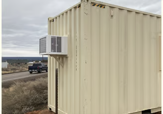A shipping container with an air conditioner on the side of it.