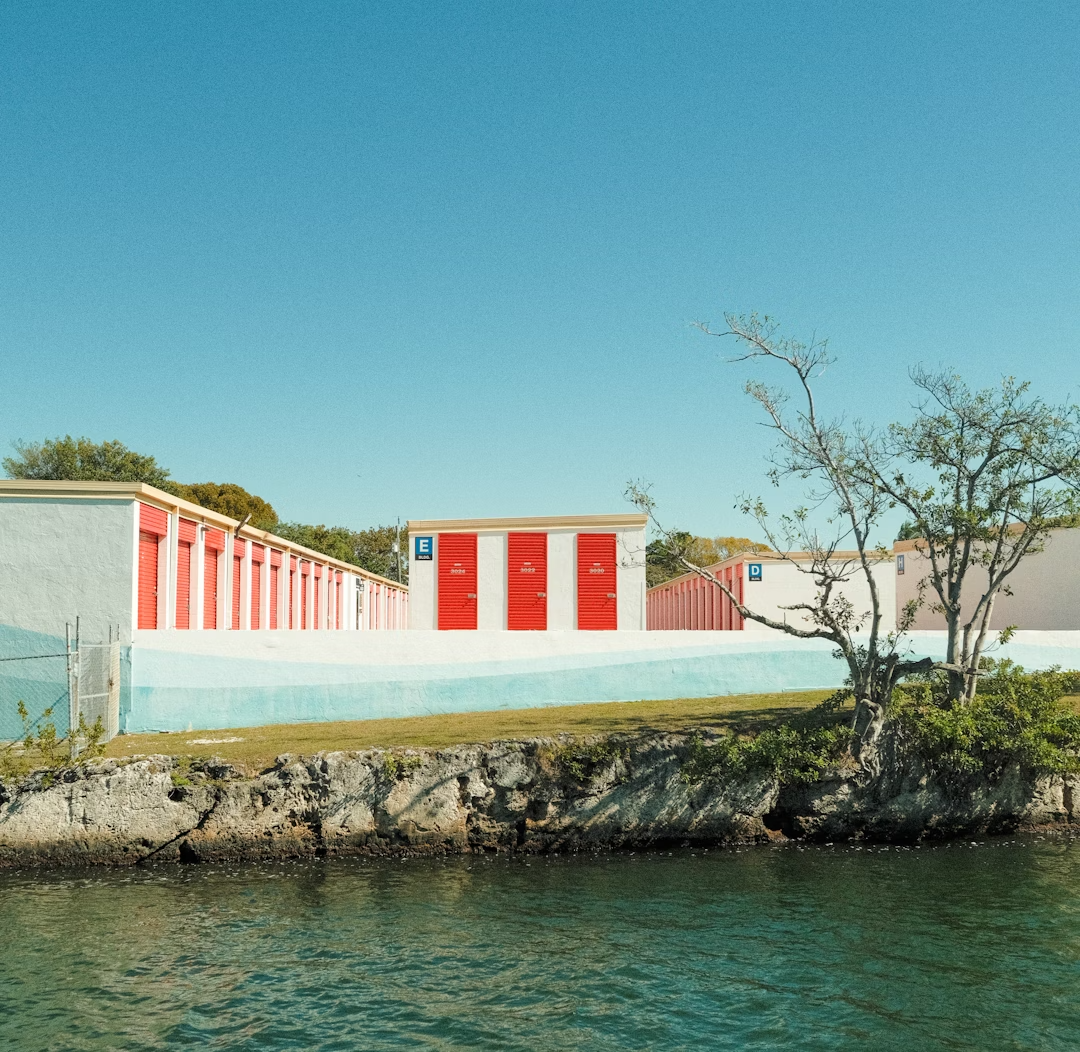 A row of red and white buildings next to a body of water