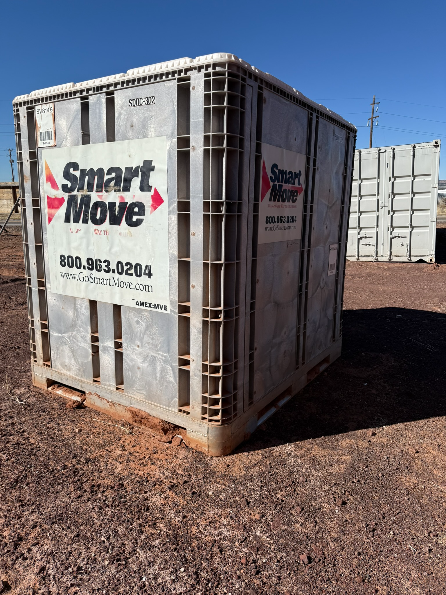 A smart move container is sitting on top of a dirt field.