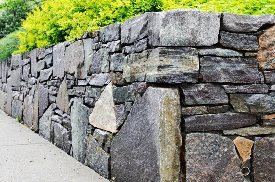 A Stone Wall Along a Sidewalk with Trees in The Background — S & L Sand & Gravel in South Lismore, NSW