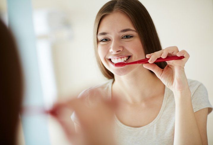 Pretty woman brushing her teeth — Ashland and Ruther Glen, VA — Ashland Family Dentistry